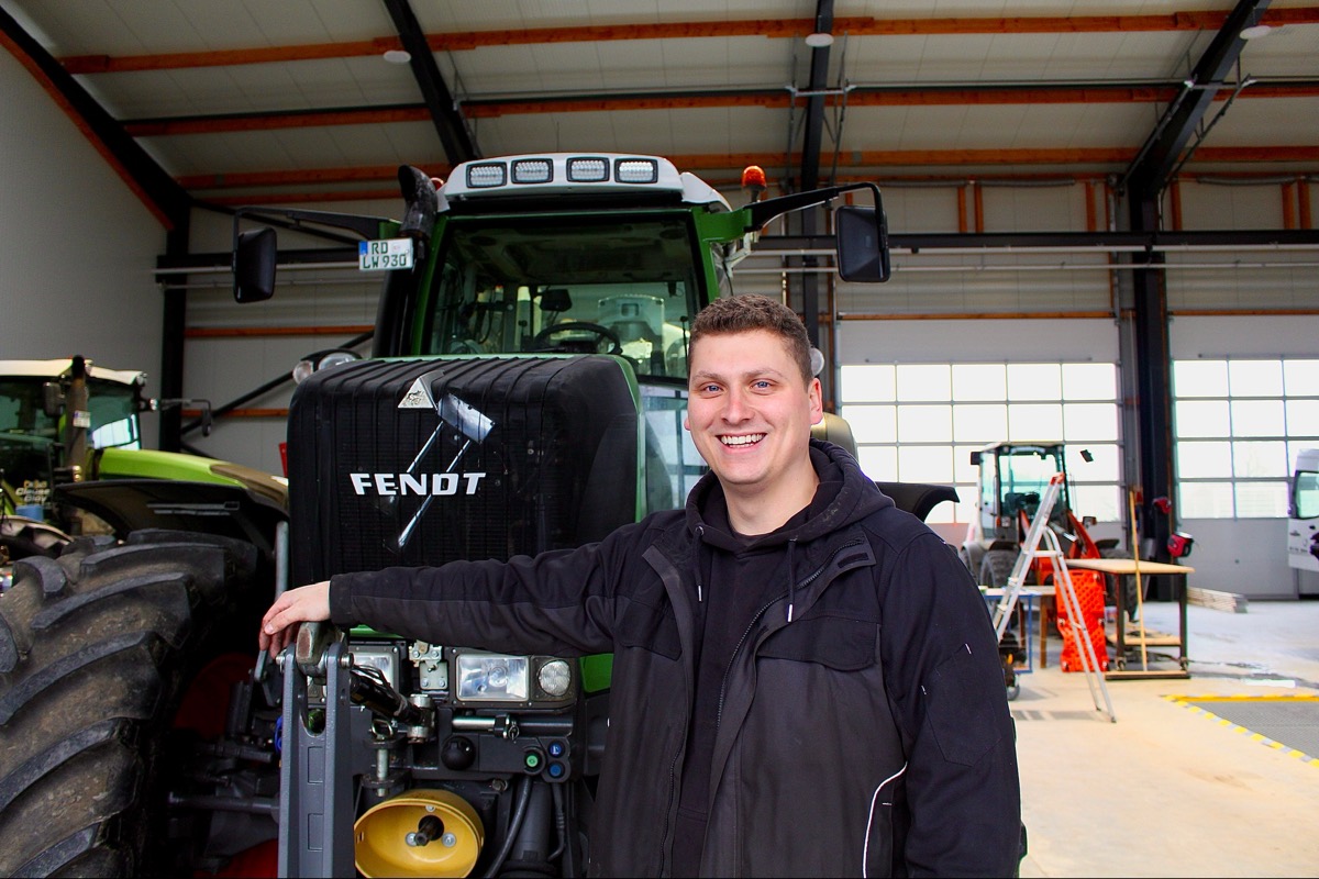 Lukas Wiegel in der Werkstatt vor einem Fendt